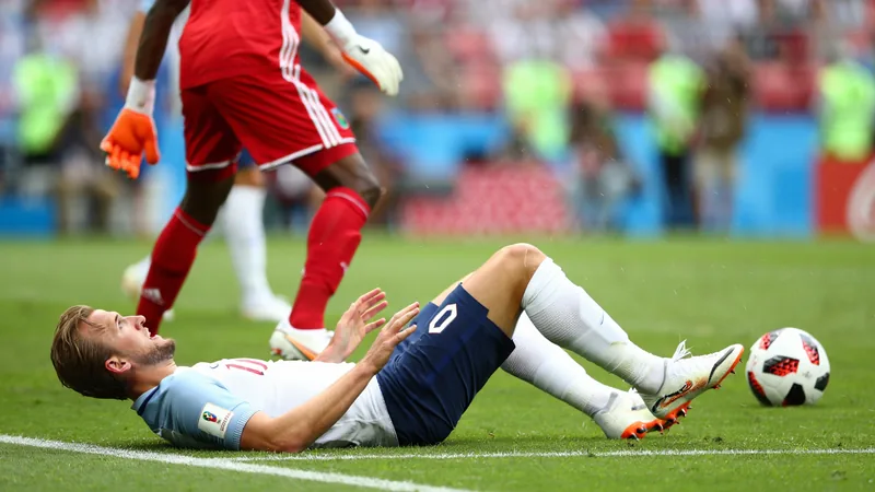 Harry Kane liegt im Strafraum am Boden, während der Torhüter der DR Congo und der Schiedsrichter auf ihn blicken. Im Hintergrund jubeln gegnerische