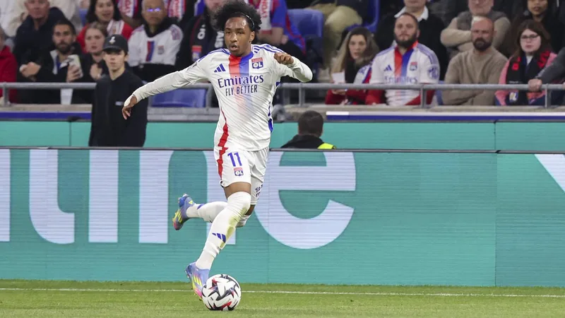 AS Rom verhandelt weiter über Malick Fofana — Football World Cup News Malick Fofana im Trikot von Olympique Lyon dribbelt mit dem Ball am Fuß auf dem Spielfeld, im Hintergrund die Tribüne des Stadions.