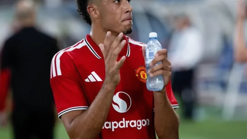 Everton an Man-United-Talent Wheatley interessiert — Football World Ein junger Fußballspieler in rotem Trikot von Manchester United läuft mit dem Ball über den Rasen, im Hintergrund das Stadion.