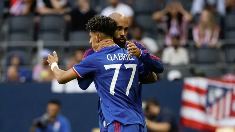 JJ Gabriel in Manchester United Trikot läuft auf den Platz, Stadionbeleuchtung im Hintergrund, junge Fans jubeln auf der Tribüne.