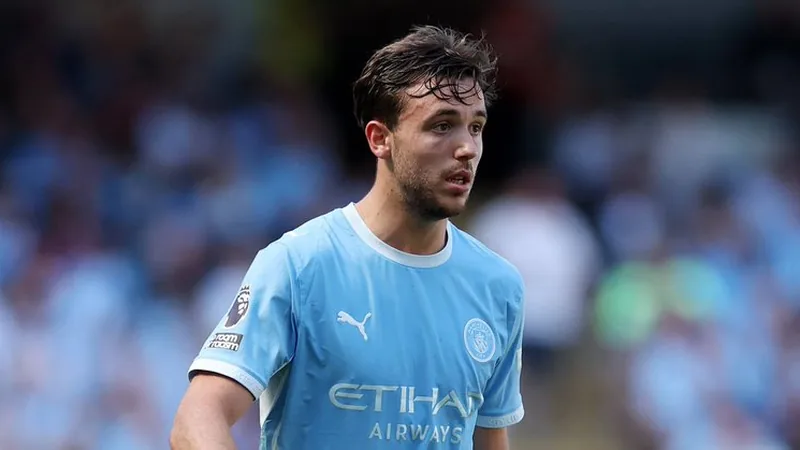 Nico Gonzalez im Trikot von Manchester City während eines Premier-League-Spiels, im Hintergrund die jubelnden Fans im Stadion.