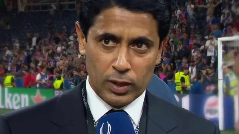 Nasser Al Khelaifi, Präsident von Paris Saint-Germain, spricht in einem Interview über Bradley Barcola, während das PSG-Logo im Hintergrund zu sehen