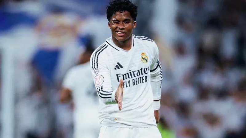 Endrick im weißen Trikot von Real Madrid während eines Spiels im Estadio Santiago Bernabéu, mit fokussiertem Blick und Ball am Fuß.