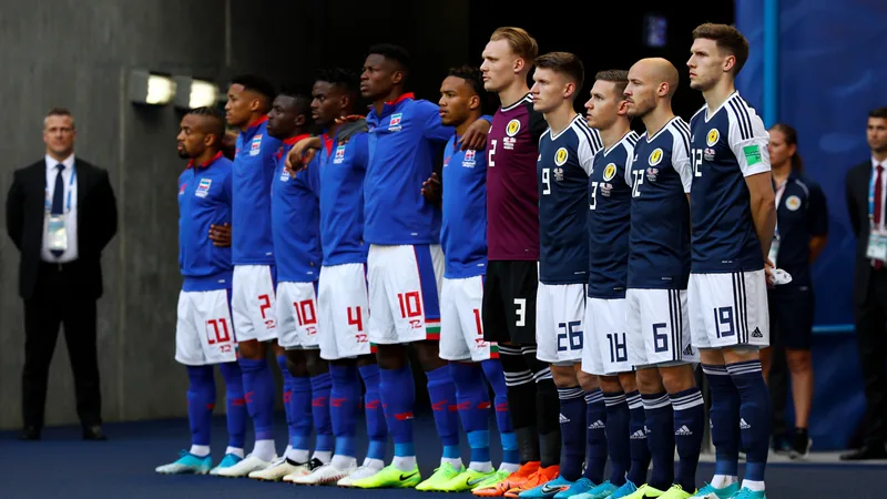 World Cup Kick-Off Delays: Why Matches Start Late Players from Haiti and Scotland line up for national anthems before a World Cup match, with a FIFA official visible in the tunnel.
