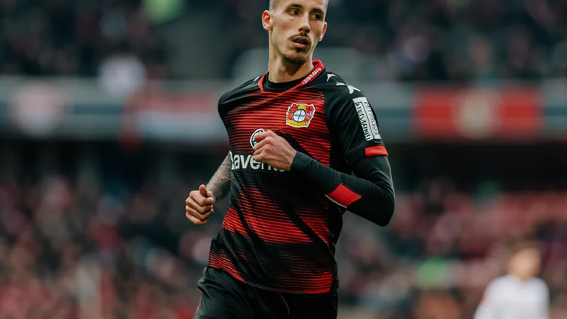 Alejandro Grimaldo celebrando un gol con la camiseta del Bayer Leverkusen en el BayArena, con aficionados al fondo. — latest news and analysis.