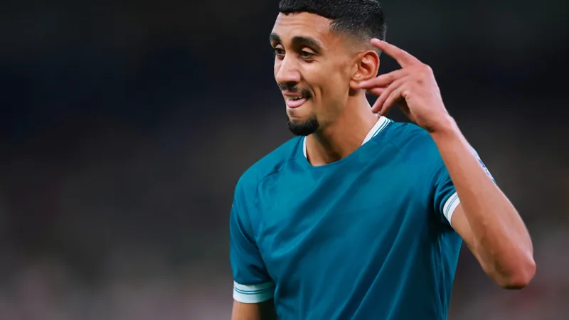 Amir Al Ammari con la camiseta de Irak celebrando en el campo de fútbol durante un partido de clasificación para la Copa Mundial.