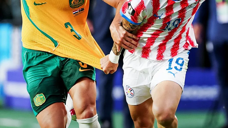 Jugadores de Australia y Paraguay en el campo de fútbol durante el partido decisivo, con la afición al fondo animando. — latest news and analysis.