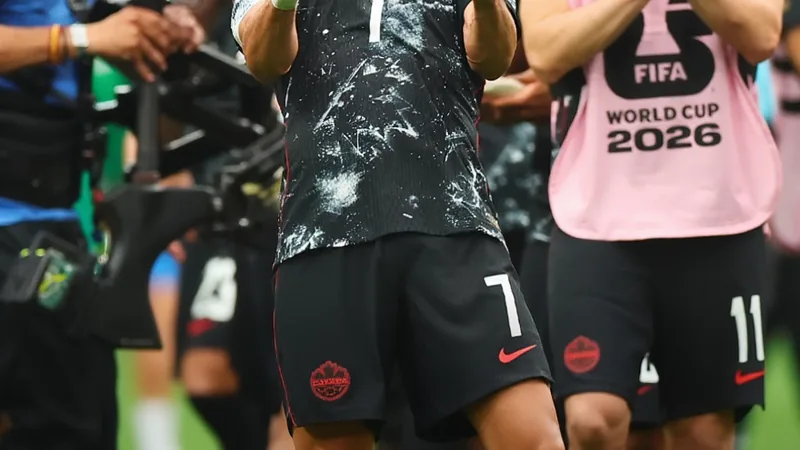 Jugadores de la selección de Canadá celebrando en el campo de fútbol tras vencer a Sudáfrica en un partido del Mundial, con el estadio lleno de