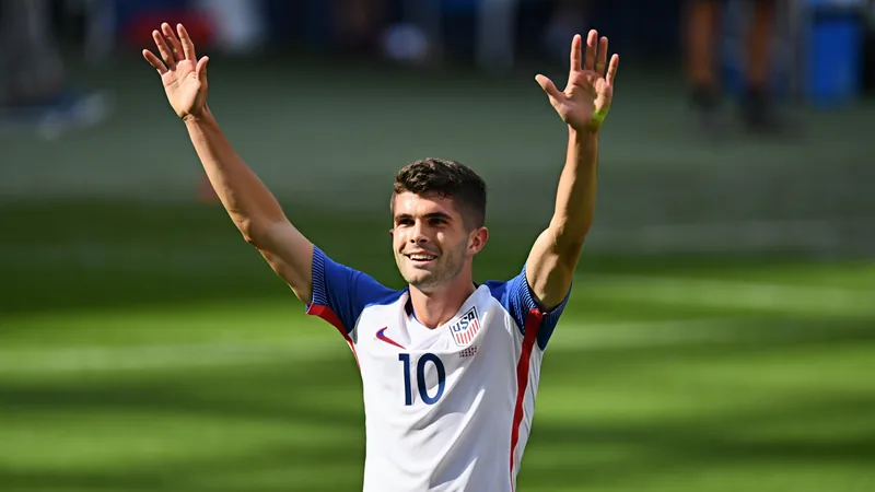 Christian Pulisic con la camiseta de la selección de Estados Unidos celebrando un gol en un estadio lleno de aficionados.