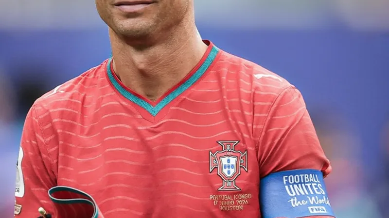Cristiano Ronaldo luce un distintivo especial en su camiseta Cristiano Ronaldo con su camiseta de juego mostrando un parche conmemorativo en el pecho, durante un partido de fútbol en un estadio lleno de