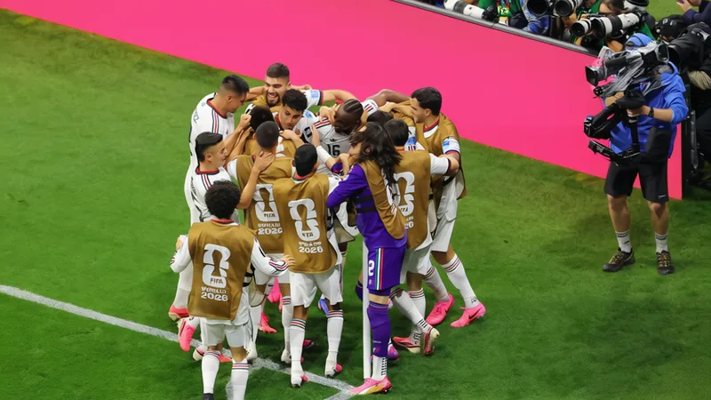 Jugadores de la selección de México abrazados en el campo de fútbol, mostrando unidad y camaradería durante un entrenamiento.