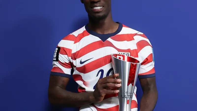 Folarin Balogun gana el Mejor Jugador de la FIFA por segunda vez Folarin Balogun celebrando con el trofeo al Mejor Jugador del Partido de la FIFA, con la camiseta de Estados Unidos y el estadio de fondo.