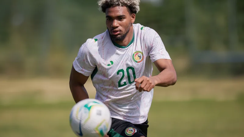 Ibrahim Mbaye se perfila como titular en Senegal — Football World Cup Ibrahim Mbaye, delantero senegalés, celebrando un gol con la camiseta de Senegal en un entrenamiento previo al Mundial, con el estadio de fondo.