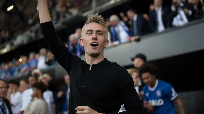 Kieran McKenna deja el Ipswich Town con 'gran orgullo' para tomarse Kieran McKenna sonriendo con la bufanda del Ipswich Town al fondo del estadio Portman Road durante un partido — latest news and analysis.