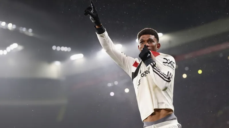 Amad Diallo con la camiseta roja del Manchester United celebrando un gol en Old Trafford ante una multitud de aficionados emocionados