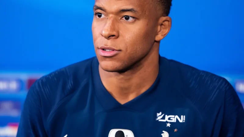 Mbappé bromea sobre rival de Francia: Senegal o Marruecos — Football Kylian Mbappé sonriendo en una rueda de prensa con la camiseta de la selección francesa, micrófonos y periodistas al fondo