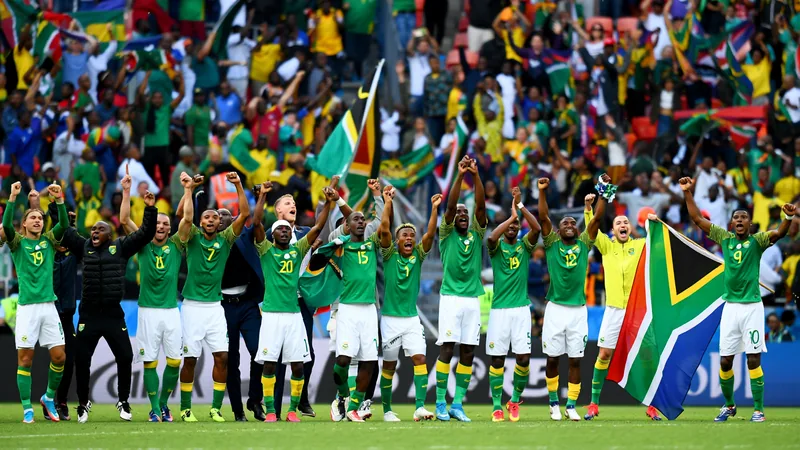 Jugadores de la selección de Sudáfrica celebrando un gol en el campo de fútbol con la bandera sudafricana de fondo — latest news and analysis.