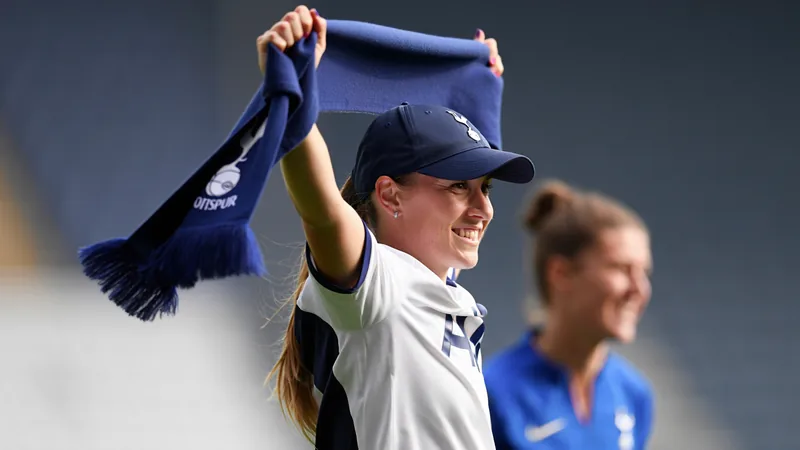 Kirsty Hanson con la camiseta del Tottenham Hotspur posando para una foto oficial de presentación en el estadio del club.