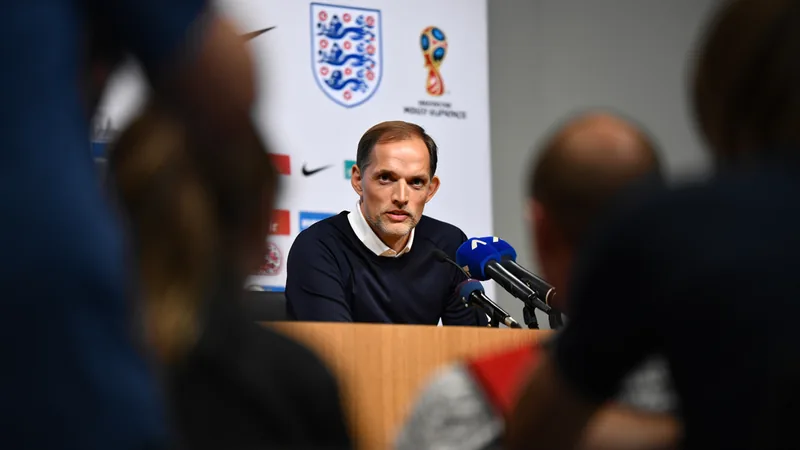 Tuchel: Inglaterra no cambiará su estilo pese al calor en EE.UU Thomas Tuchel en la banda durante un partido de Inglaterra, con el estadio cubierto de fondo y jugadores sudando bajo el calor.