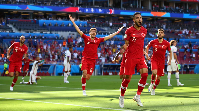 Jugadores de Turquía celebrando un gol en el SoFi Stadium de Los Ángeles ante una multitud, con el marcador mostrando 3-2 en tiempo de descuento.