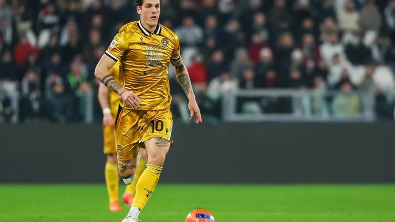 Nicolò Zaniolo celebra un gol con la camiseta del Udinese en el estadio Friuli, con aficionados de fondo animando al equipo local durante un partido
