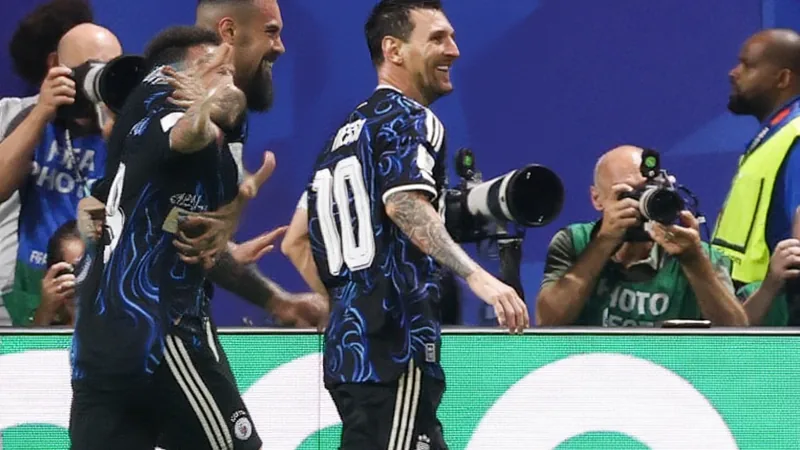 Argentina se adelanta con asistencia de Messi; Lautaro Martínez marca Lionel Messi celebrando con Lautaro Martínez tras el gol del 2-1, con la camiseta albiceleste y el estadio de fondo lleno de aficionados argentinos.