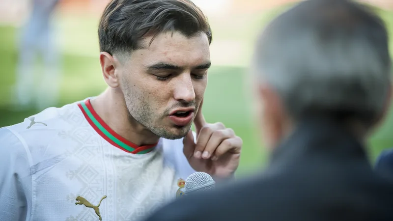 Brahim Díaz: "Es mejor que Francia clasifique" — Football World Cup Brahim Díaz con la camiseta del AC Milan sonriendo durante una entrevista en un estudio de radio con micrófonos y luces de fondo.