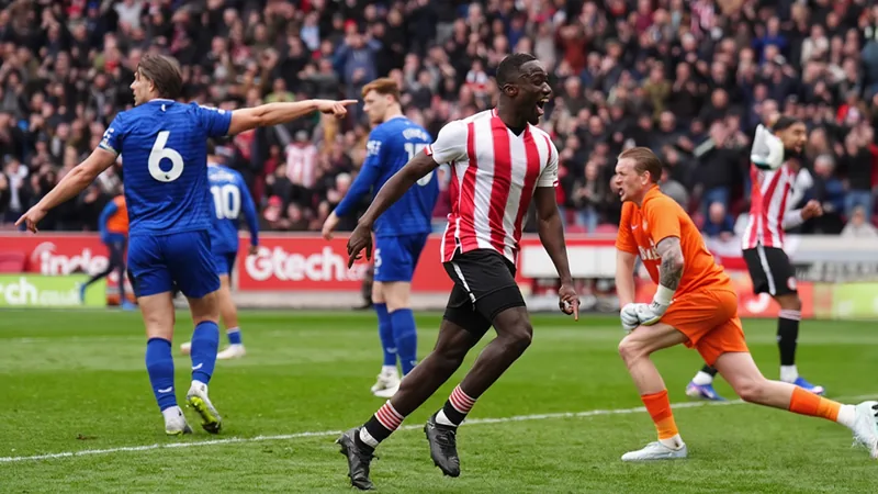 Brentford blinda a Michael Kayode hasta 2032 — Football World Cup News Michael Kayode con la camiseta del Brentford celebrando un gol en el estadio comunitario, con aficionados de fondo vitoreando su renovación hasta 2032