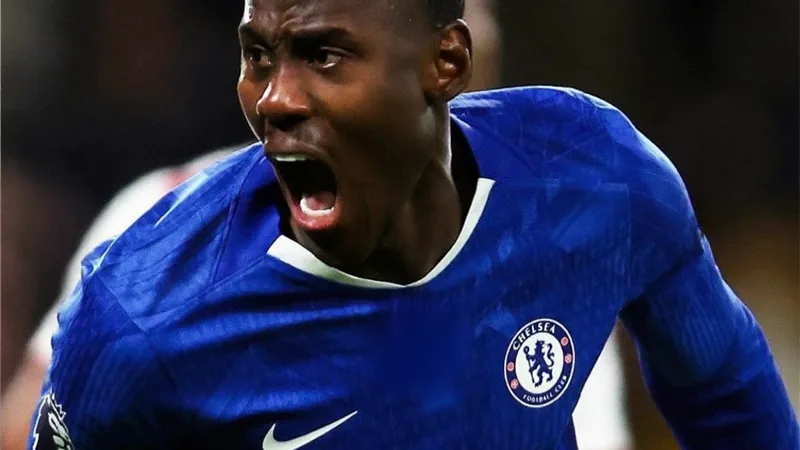 Trevoh Chalobah con la camiseta del Chelsea durante un partido de la Premier League, con el estadio de fondo y el balón en juego.