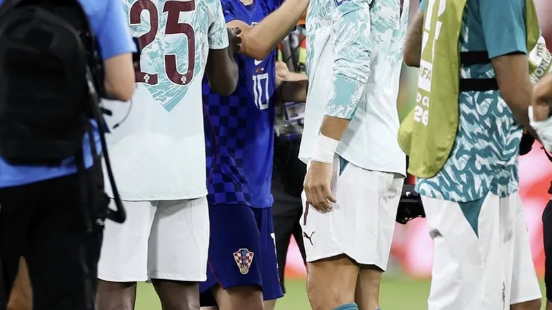 Cristiano Ronaldo abraza a Luka Modrić en el campo de fútbol tras el partido, con el estadio de fondo y aficionados vitoreando.