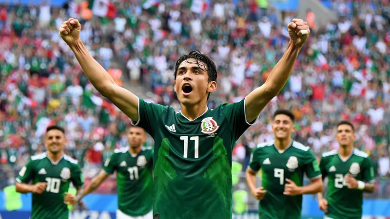 El héroe improbable de México que Inglaterra debería temer — Football Julián Quiñones celebra un gol con la camiseta de México en el Estadio Azteca, con aficionados al fondo ondeando banderas mexicanas.