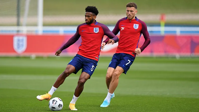 Jarell Quansah y Anthony Gordon posan con la camiseta de Inglaterra en el campo de entrenamiento antes del partido contra México en la Copa del Mundo.