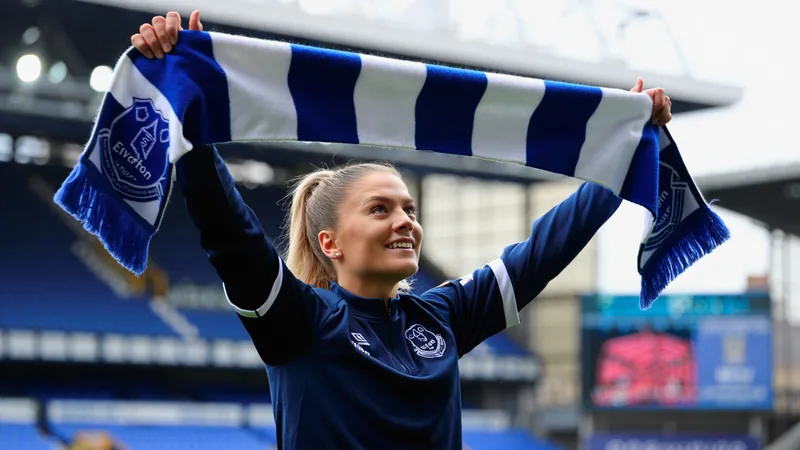 Holly McNamara ficha por el Everton — Football World Cup News Holly McNamara posa con la camiseta del Everton en Goodison Park, con el estadio de fondo y una pelota de fútbol en primer plano.