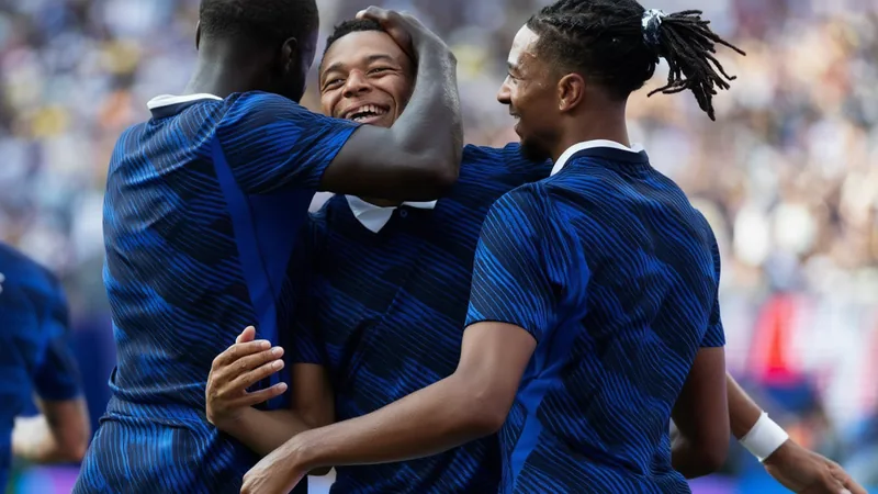 La revolución ofensiva de Francia: Deschamps desafía su historia Jugadores de la selección francesa celebrando un gol en un partido de fútbol, con Didier Deschamps en el banquillo observando.