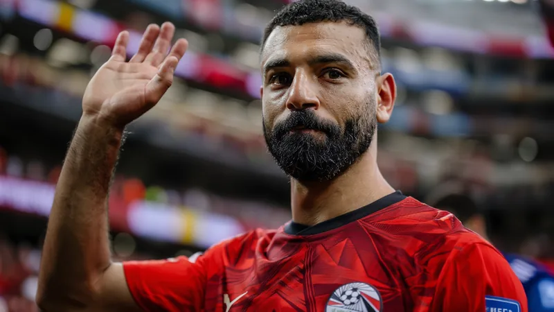 Mo Salah evalúa ofertas de Arabia Saudí y la MLS — Football World Cup Mohamed Salah con la camiseta del Liverpool celebrando un gol en Anfield, con aficionados de fondo y el estadio iluminado.