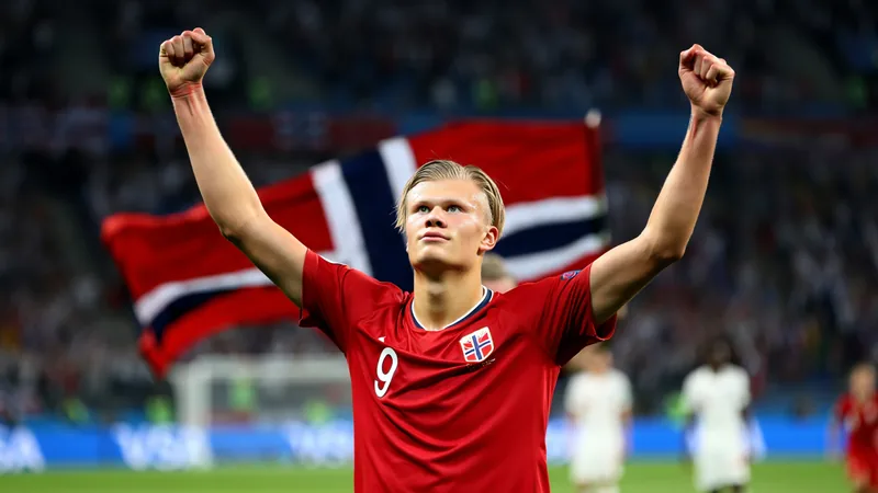 Erling Haaland con la camiseta de Noruega celebrando un gol en un estadio lleno de banderas rojas y blancas — latest news and analysis.