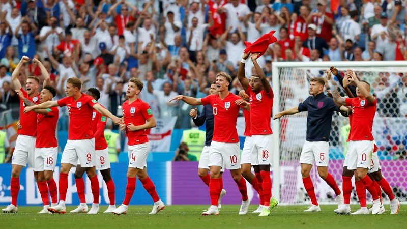 Jugadores de la selección inglesa celebrando una victoria en un estadio lleno de aficionados con banderas de Inglaterra — latest news and analysis.