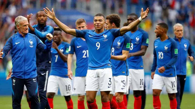 Unidos, libres y brillantes: ¿alguien puede frenar a Francia Jugadores franceses abrazan a Didier Deschamps tras un gol, con Kylian Mbappé al frente, en un estadio lleno de banderas francesas.
