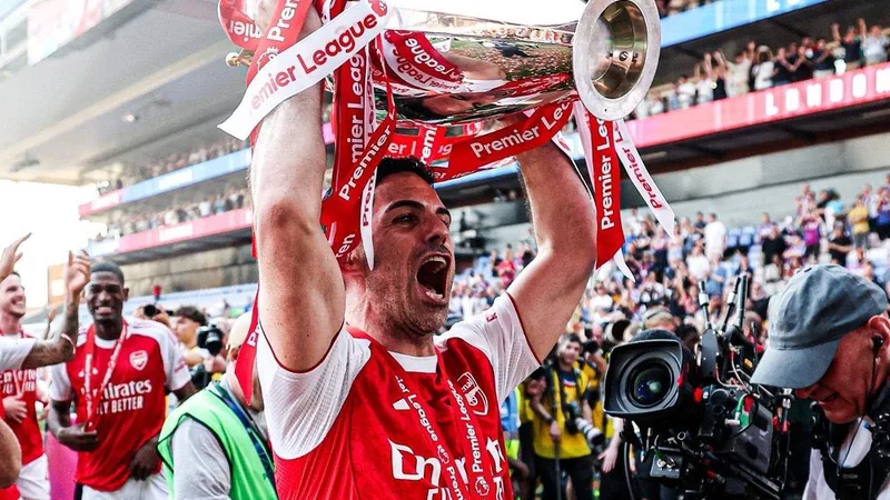 Mikel Arteta, entrenador del Arsenal, sonriendo en el banquillo del Emirates Stadium durante un partido de la Premier League.
