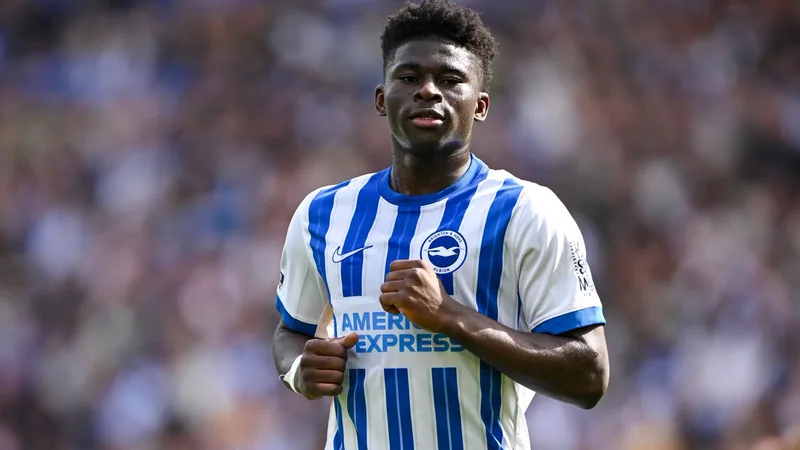 Carlos Baleba, centrocampista camerunés del Brighton, con el balón en un partido de la Premier League, con el estadio de fondo.