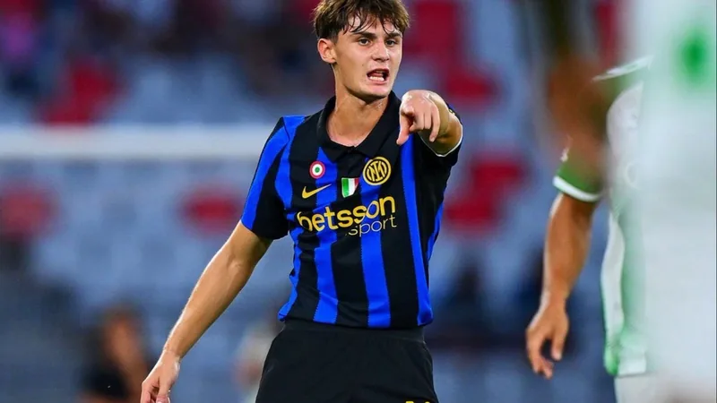 Leonardo Bovio renueva con el Inter — Football World Cup News Joven defensor Leonardo Bovio con la camiseta del Inter de Milán firmando un contrato en las oficinas del club, con trofeos de fondo.
