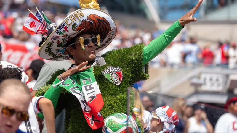Stade de football rempli de supporters mexicains et sud-africains agitant des drapeaux, avec le logo de la Coupe du Monde FIFA 2026 au centre du