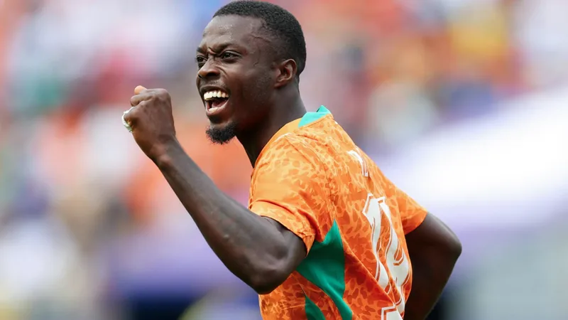Joueurs ivoiriens célébrant un but lors du match amical Curaçao-Côte d'Ivoire, avec le maillot orange des Éléphants visible au premier plan.