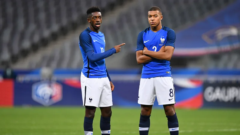 Ousmane Dembélé et Kylian Mbappé souriant lors d'un entraînement de l'équipe de France, maillots bleus, terrain vert. — latest news and analysis.