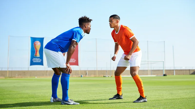 Deux frères footballeurs en tenue d'équipe adverse se serrant la main avant un match de Coupe du monde, stade rempli de supporters en arrière-plan.