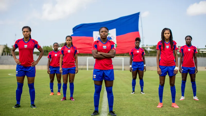 Haïti : les chefs de gangs amoureux du foot, l'espoir renaît Supporters haïtiens en liesse dans les rues de Port-au-Prince, agitant des drapeaux bleus et rouges devant des bâtiments colorés.