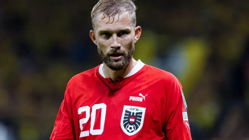 Konrad Laimer en tenue du Bayern Munich, souriant lors d'un entretien, avec un micro de la FIFA devant un fond neutre. — latest news and analysis.