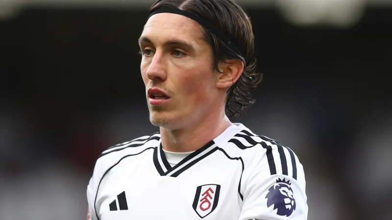 Harry Wilson en tenue de Leeds United posant avec un maillot du club dans le stade Elland Road — latest news and analysis.