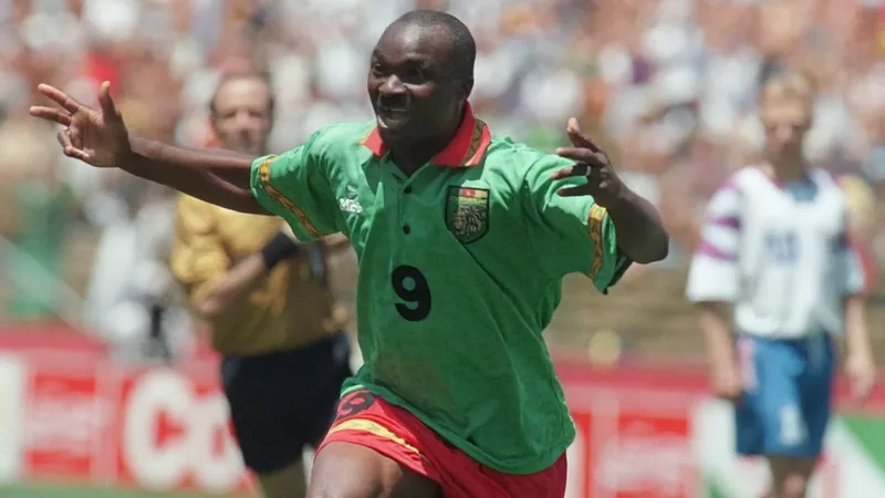 Roger Milla célébrant son but contre la Russie lors de la Coupe du Monde 1994, entouré de coéquipiers camerounais en maillot vert.