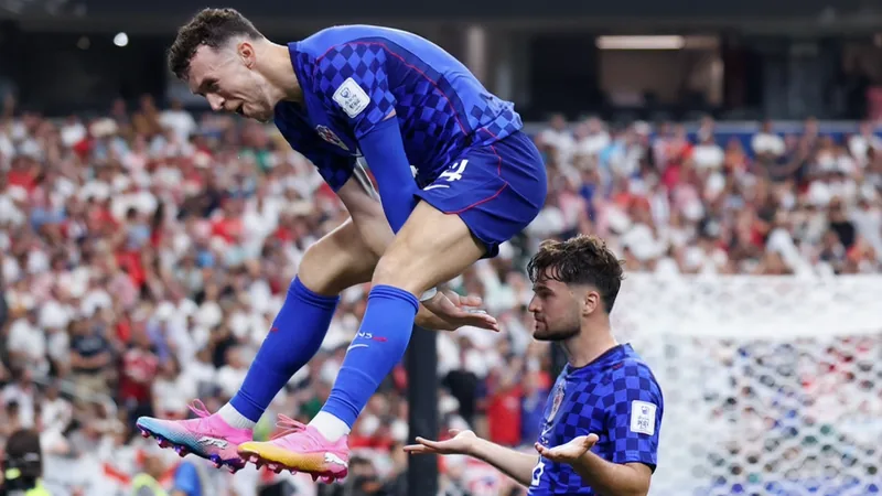 Martin Baturina marque un but d'anthologie pour ses débuts en Coupe Martin Baturina célébrant son but avec ses coéquipiers croates sur la pelouse d'un stade de Coupe du Monde, le public en liesse en arrière-plan.